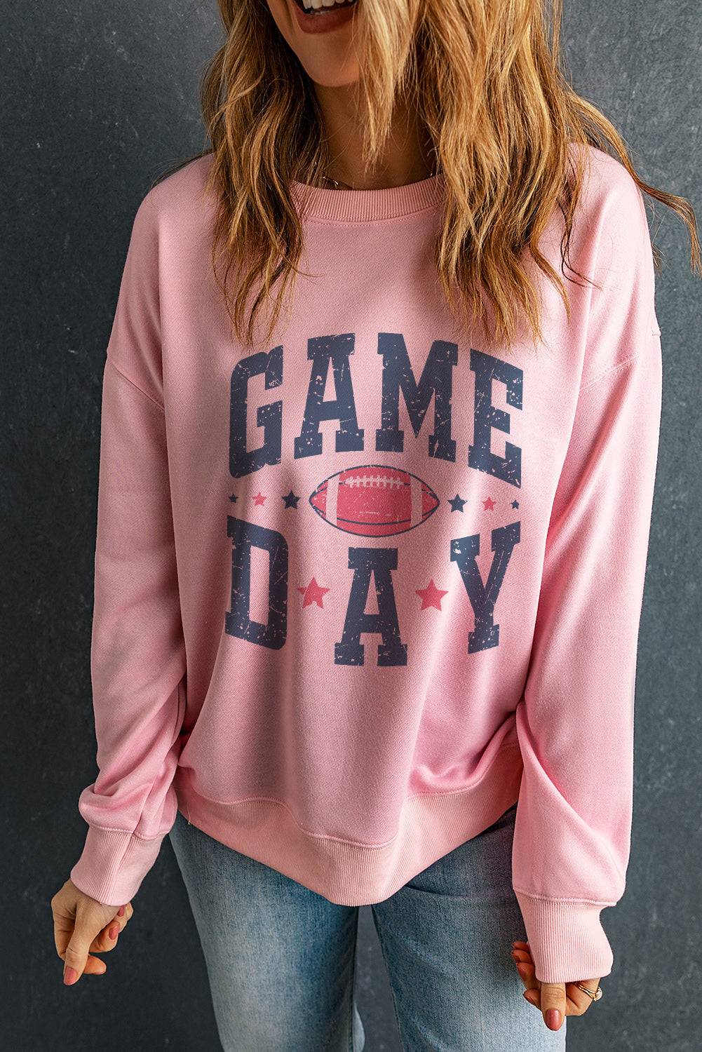 a woman wearing a pink game day sweatshirt