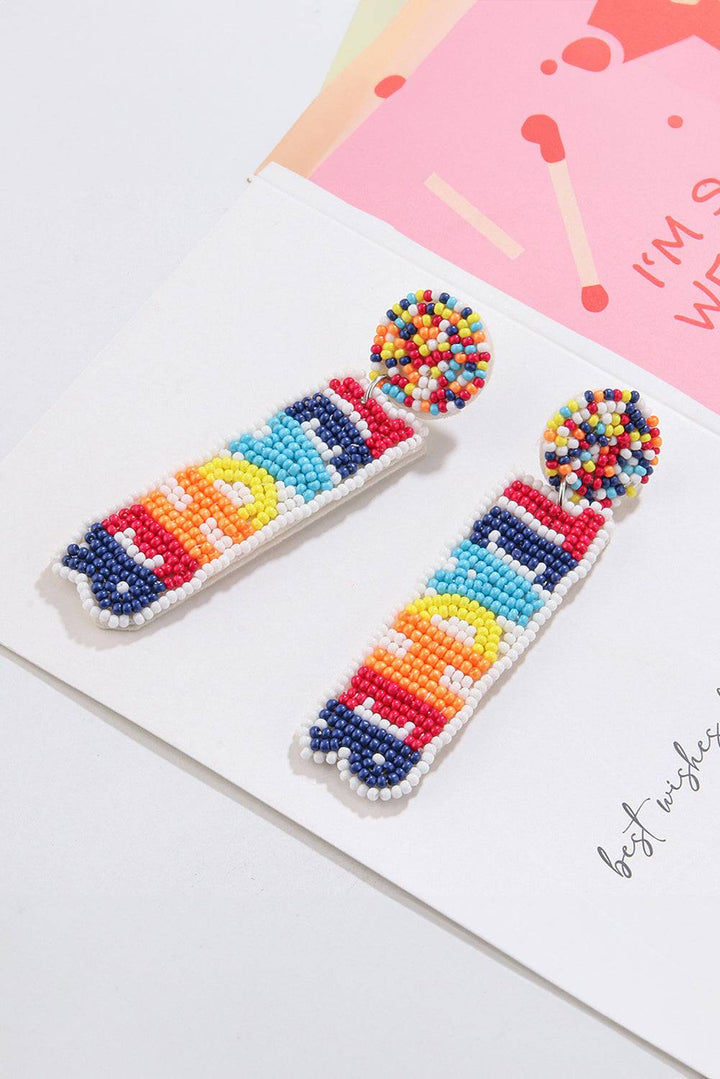 a pair of colorful beaded earrings sitting on top of a card