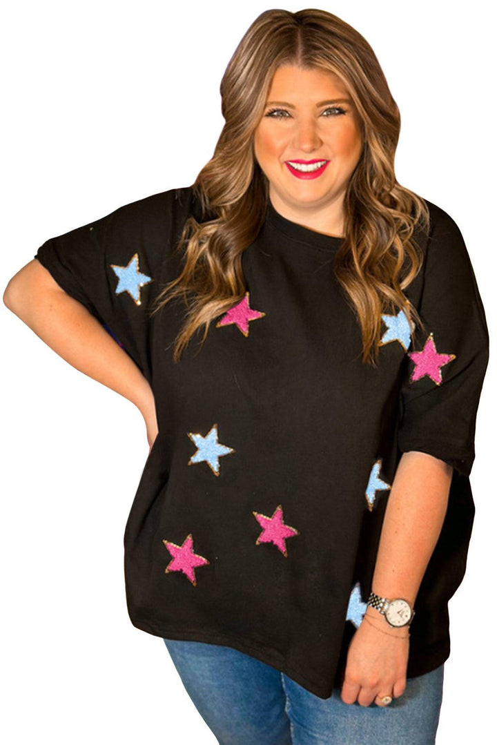 a woman wearing a black top with pink and blue stars on it