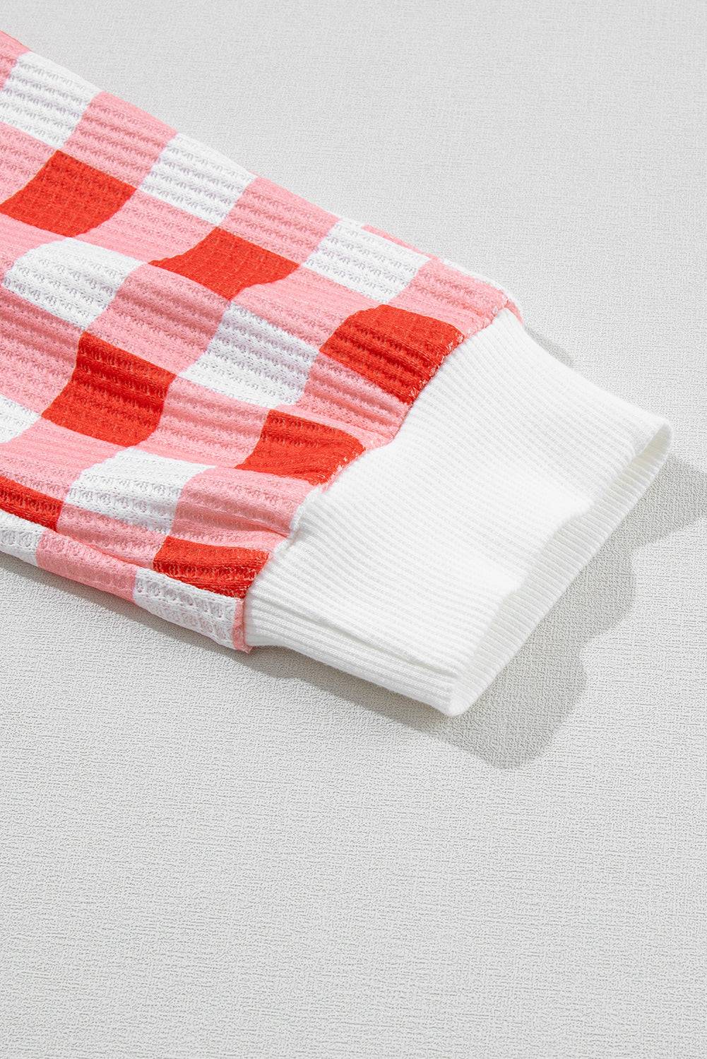 a red and white checkered blanket laying on top of a table