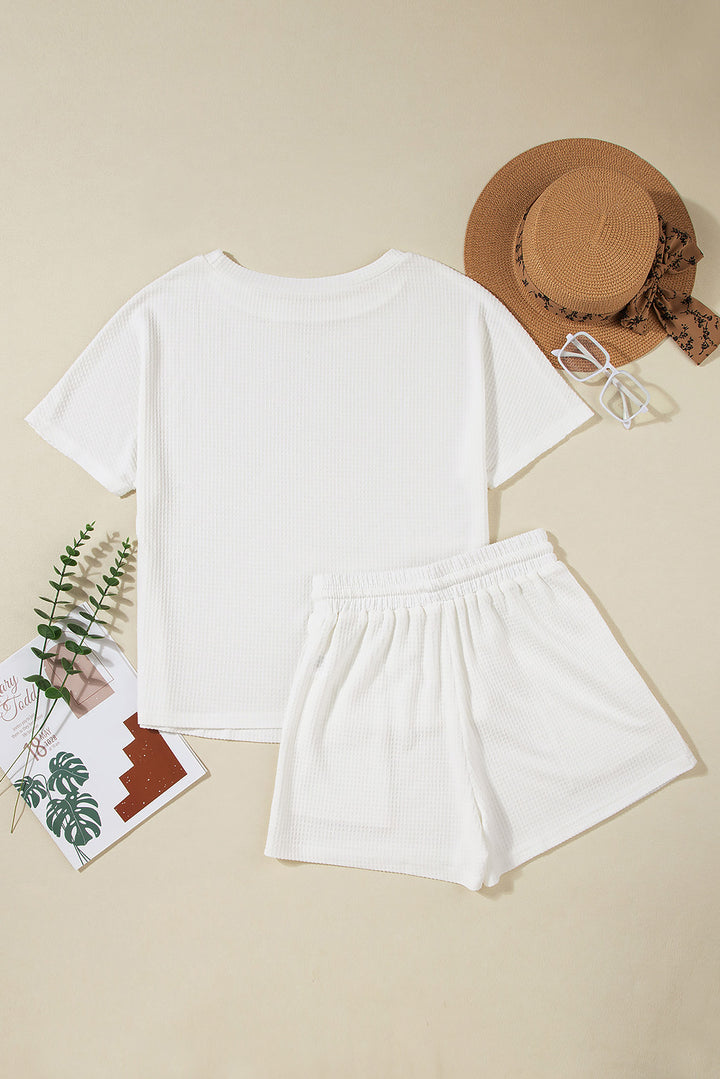a white t - shirt and shorts with a hat on top of it