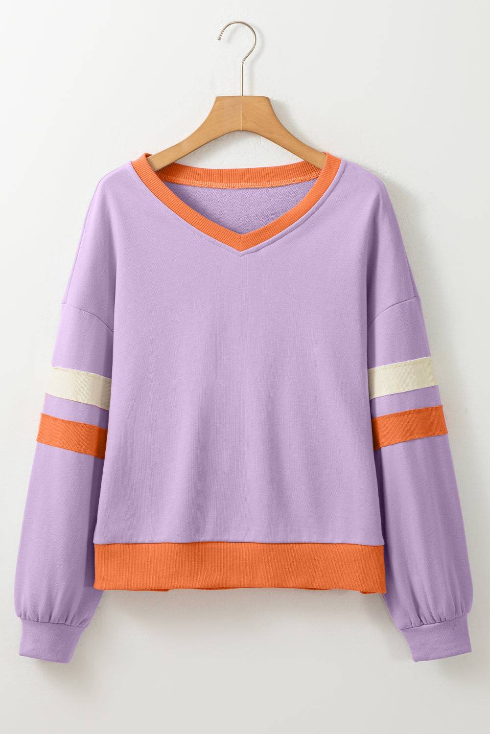 a purple sweater with an orange stripe is hanging on a hanger