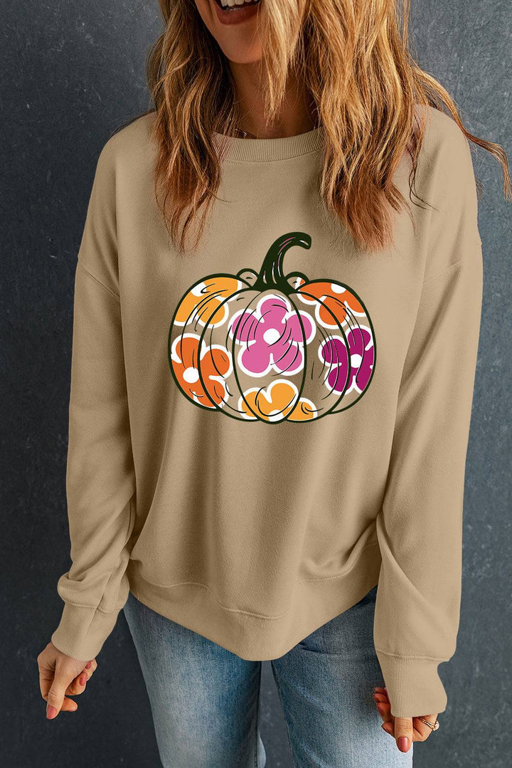 a woman wearing a sweatshirt with a pumpkin on it