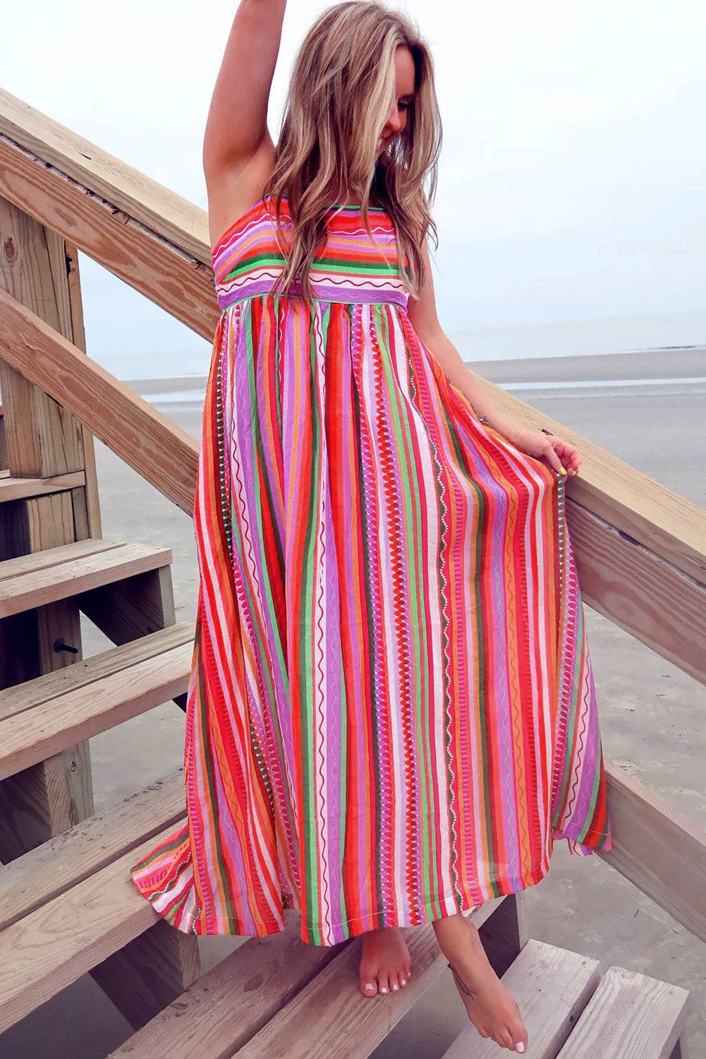 a woman in a colorful dress standing on a beach