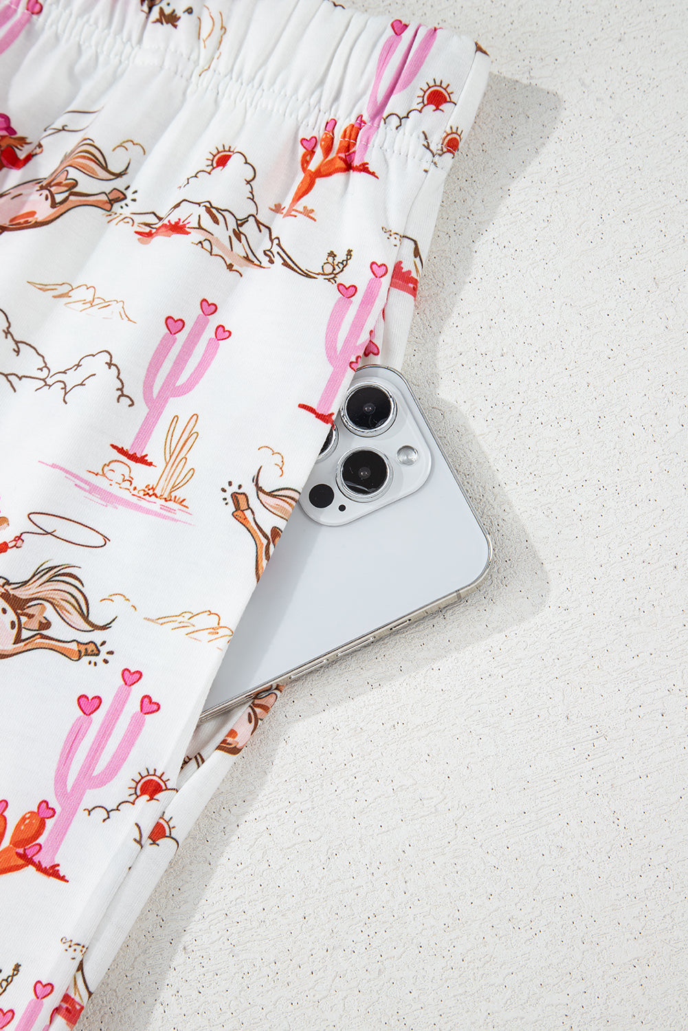 Top view of White Cowgirl Country Print Pajamas Set with pink piping and chest pocket. Shop White Cowgirl Country Print Pajamas Set at Faith & Co. Boutique.