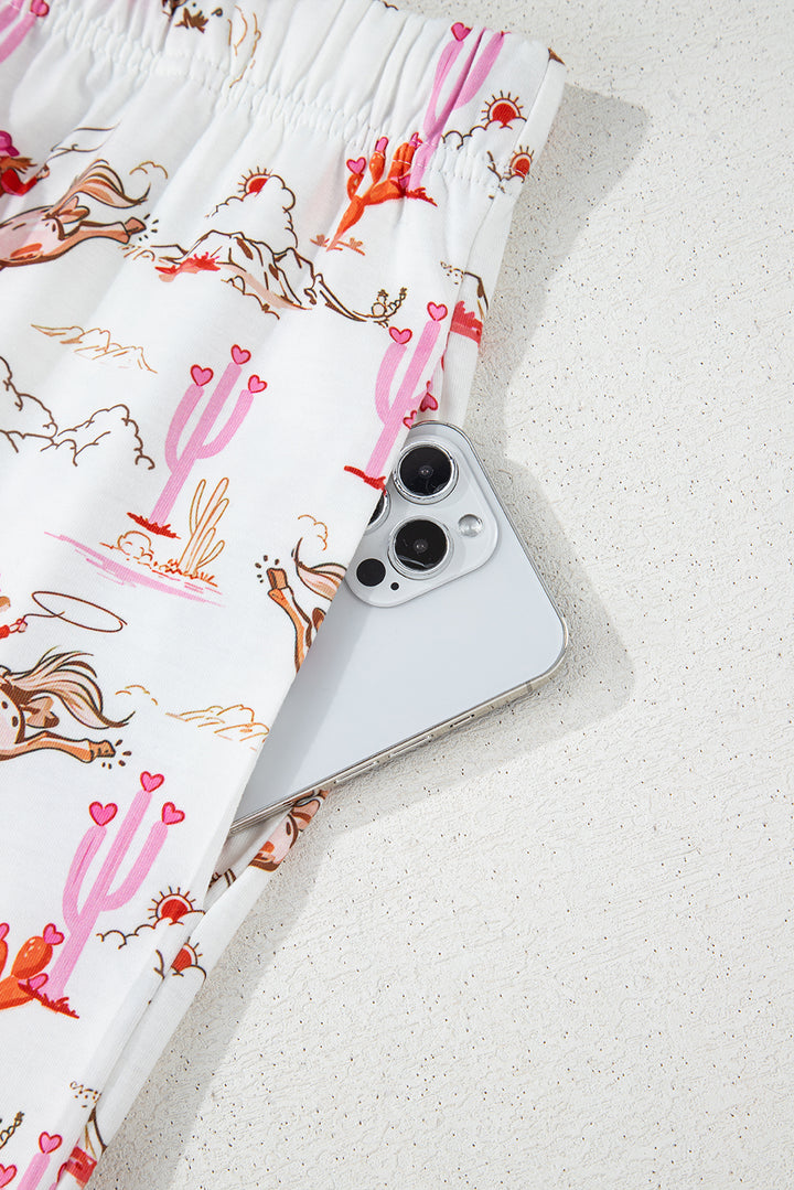 Top view of White Cowgirl Country Print Pajamas Set with pink piping and chest pocket. Shop White Cowgirl Country Print Pajamas Set at Faith & Co. Boutique.