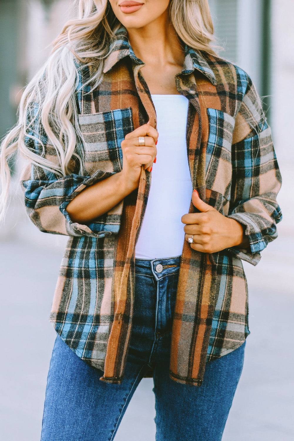 a woman wearing a plaid jacket and jeans