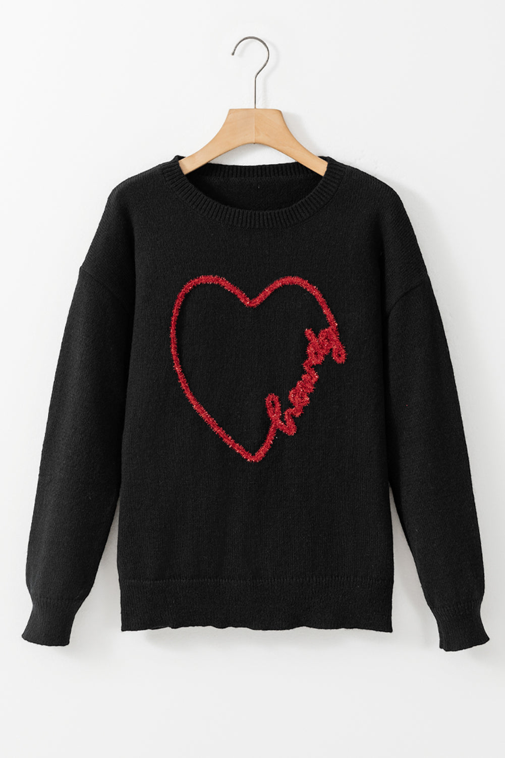 a black sweater with a red heart on it