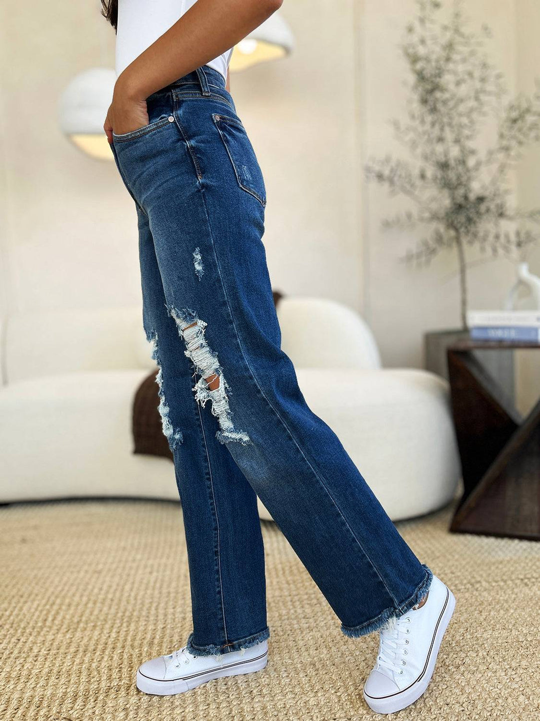 a woman in white shirt and jeans standing in a room