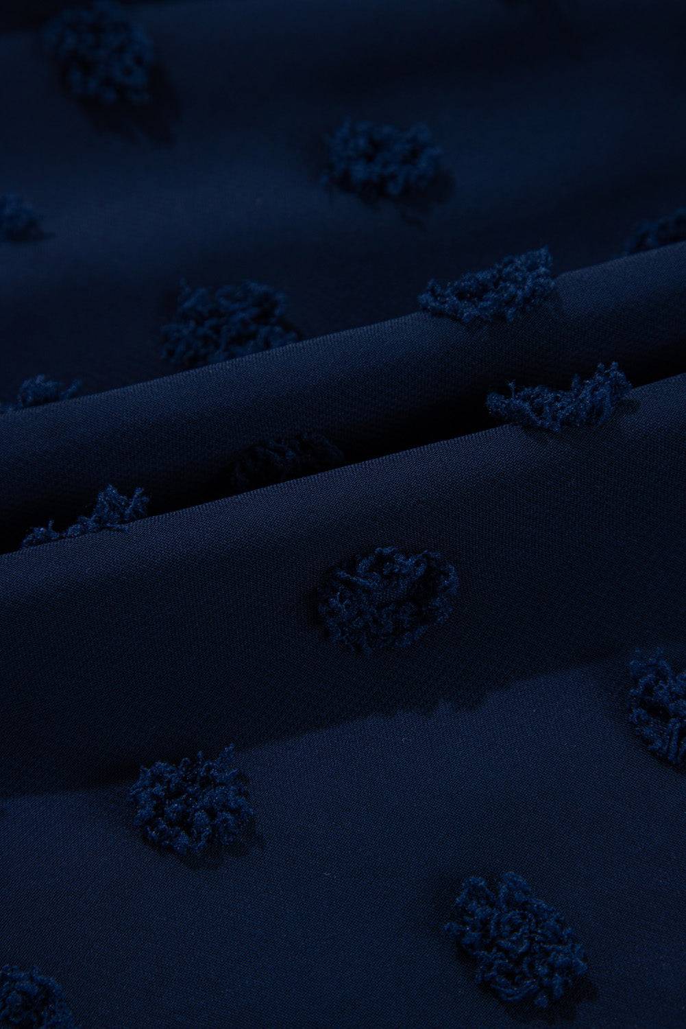 Fabric close-up of Navy Blue Dotty Textured Notched Neck Plus Ruffled Dress showing raised Swiss dot detailing for a chic summer look.