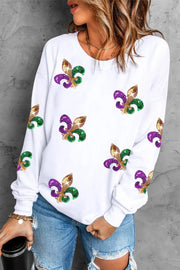 a woman wearing a white sweatshirt with colorful fleur de lis on it