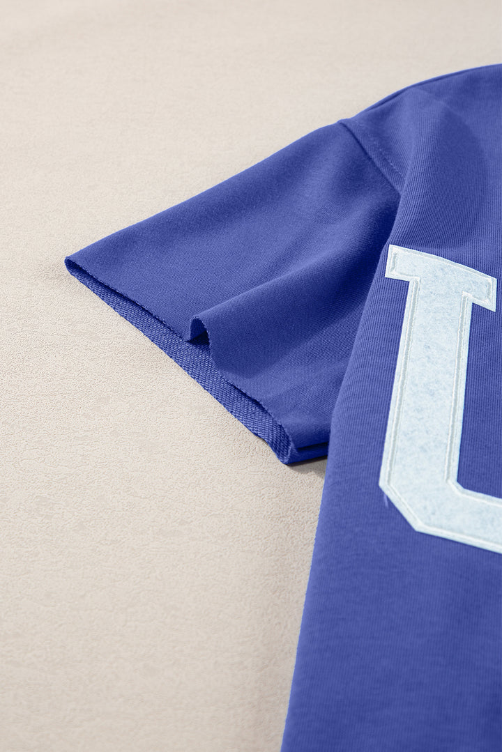 a close up of a blue shirt with the letter l on it