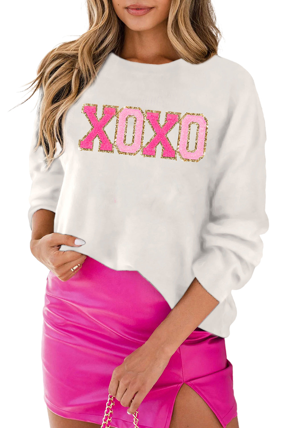 a woman wearing a white sweatshirt and pink skirt