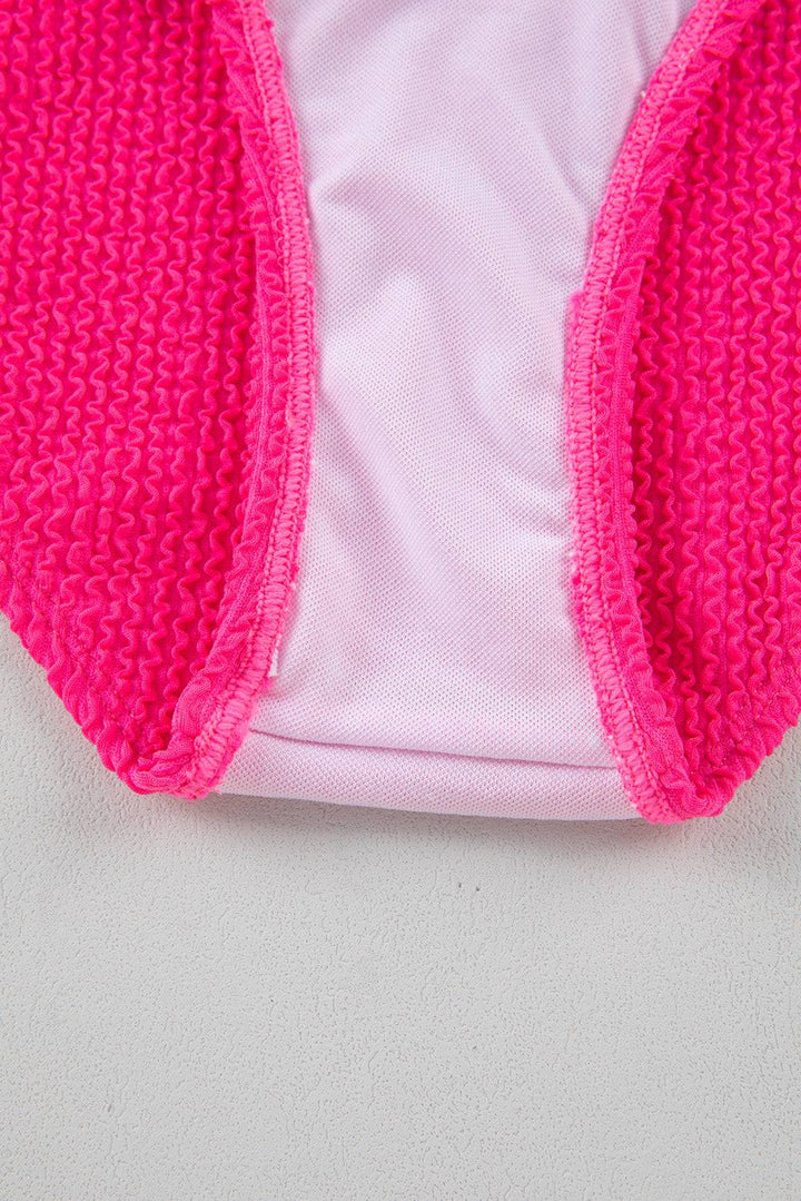 a close up of a pink jacket on a white surface