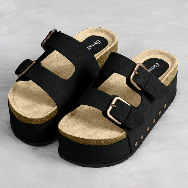 a pair of black and gold sandals on a white surface