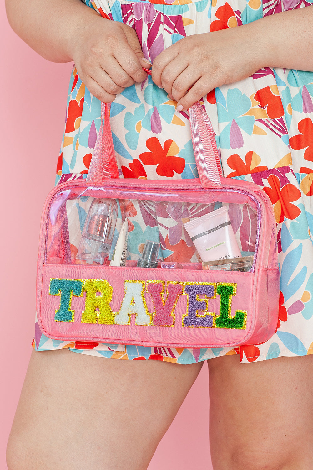 a woman is holding a pink travel bag