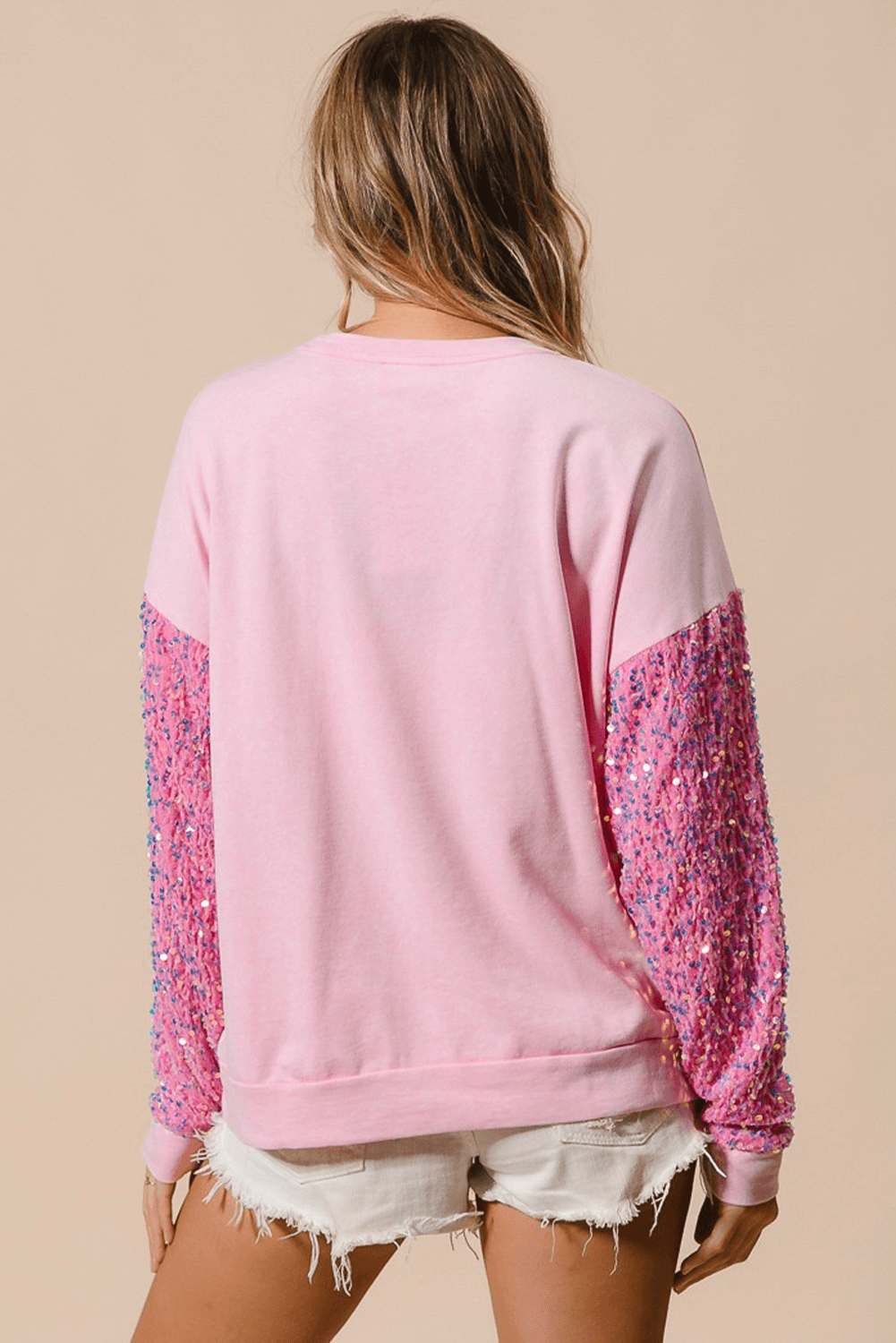 Back view of pink Moonlight Jade Christmas sweatshirt with glittery sequin sleeves, casual winter fashion from Faith & Co. Boutique.