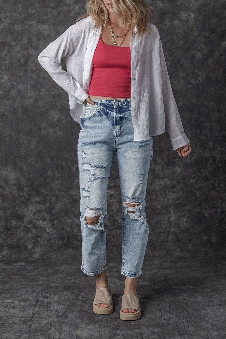 a woman in ripped jeans and a red top