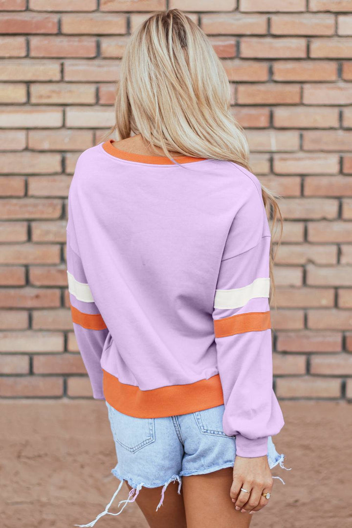 a woman wearing a purple sweater and denim shorts