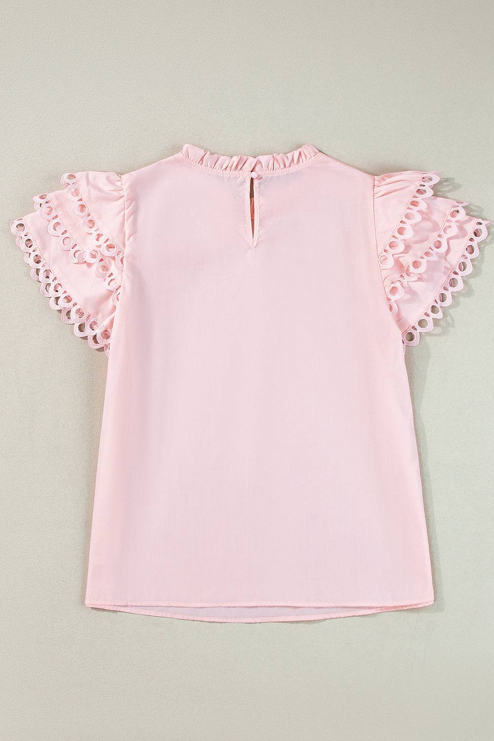 a pink top with ruffles on the sleeves