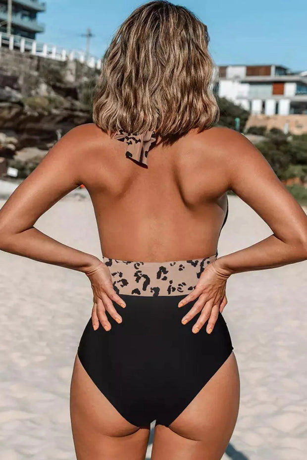 a woman in a black and leopard print swimsuit