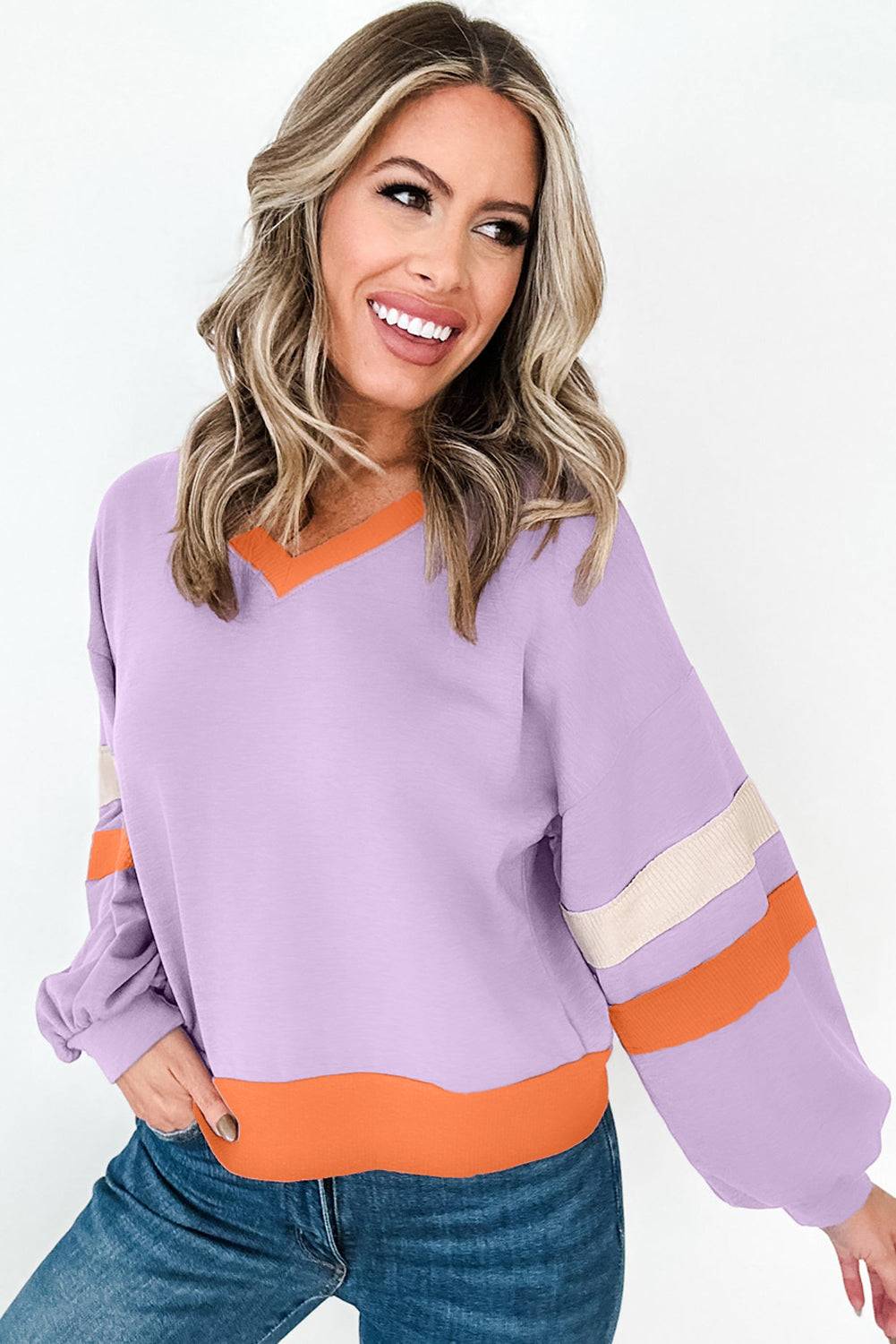 a woman wearing a purple and orange sweater