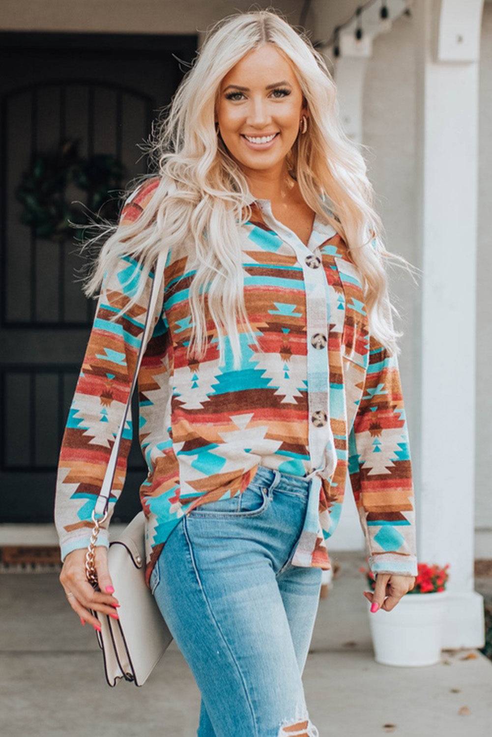 a woman wearing a colorful sweater and ripped jeans