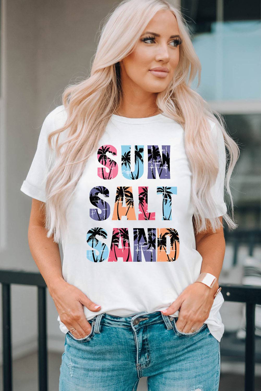 a woman wearing a white t - shirt with the words sun, sand, and