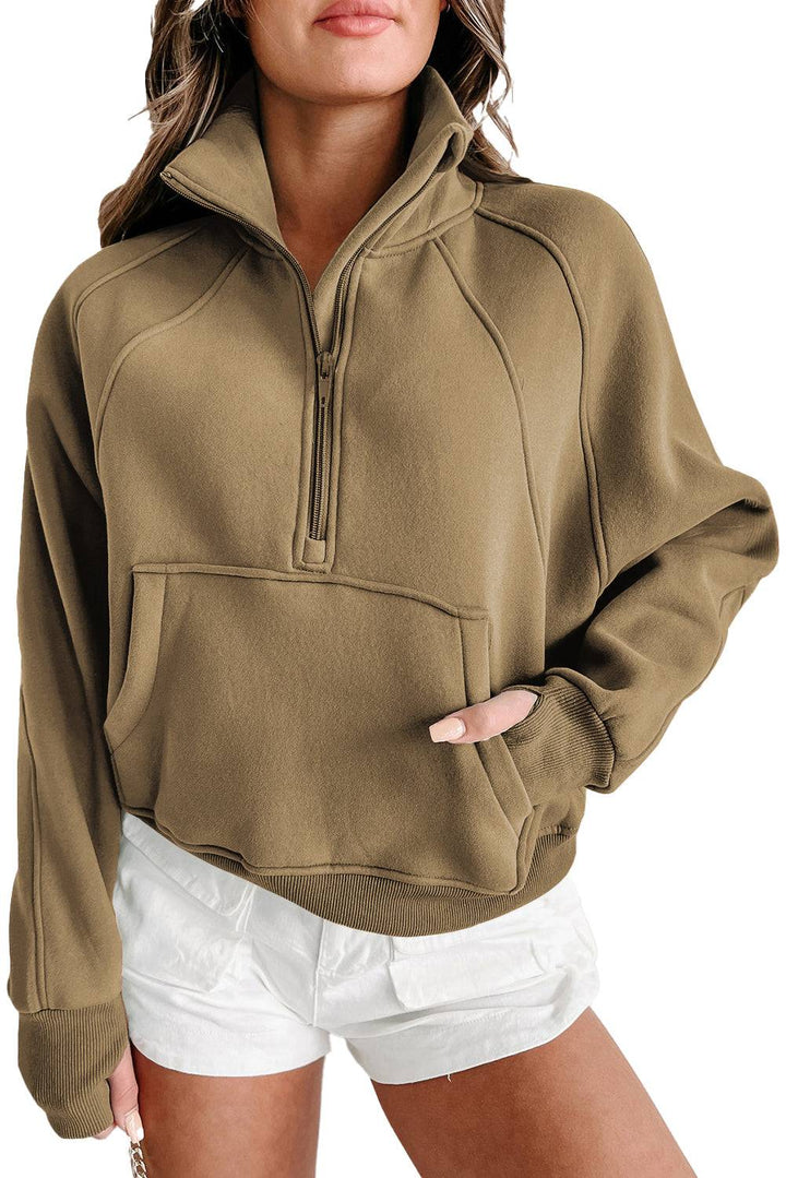 a woman wearing a brown sweatshirt and white shorts