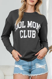 a woman wearing a sweatshirt that says wolf mom club