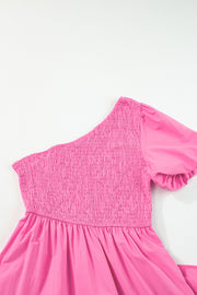 a pink dress hanging on a white wall