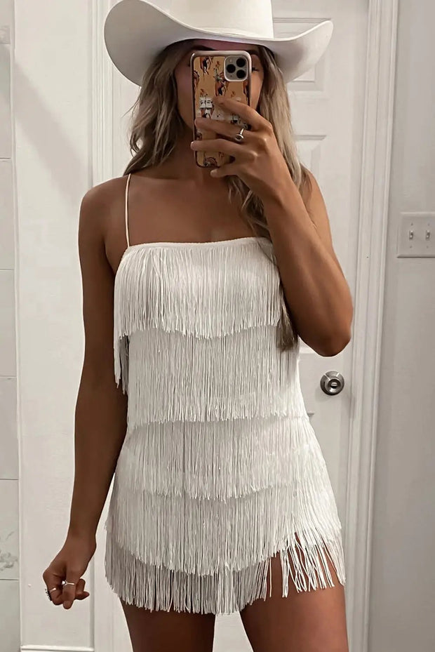a woman taking a selfie wearing a white fringe dress