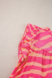 a pink and orange striped dress hanging on a wall