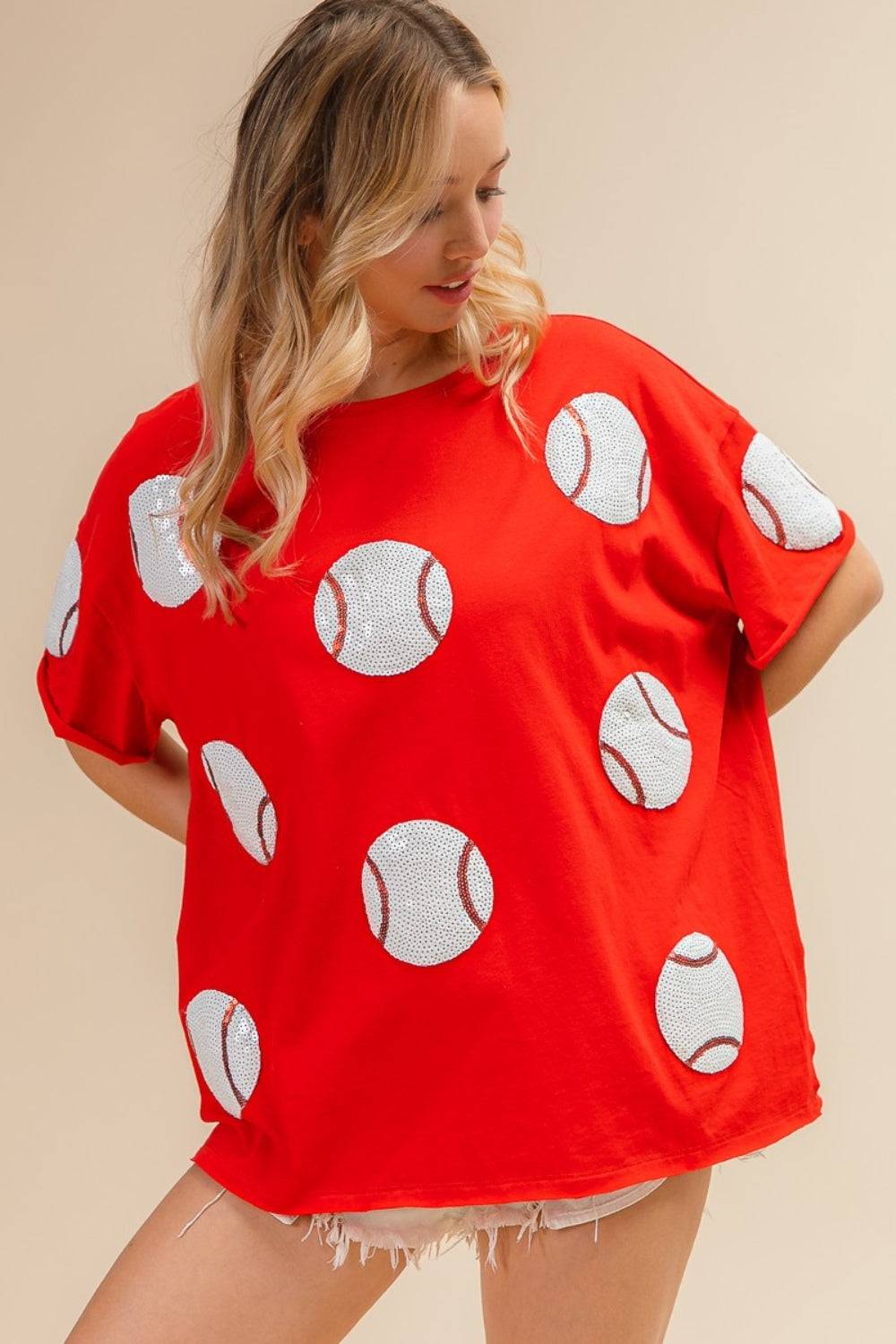 a woman wearing a red shirt with white polka dots on it