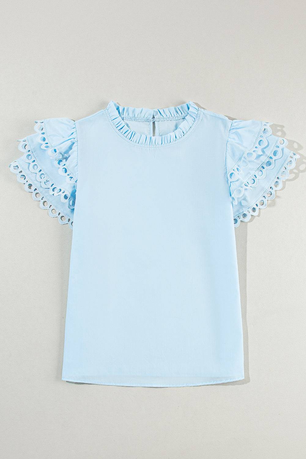 a baby blue shirt with ruffles on the sleeves
