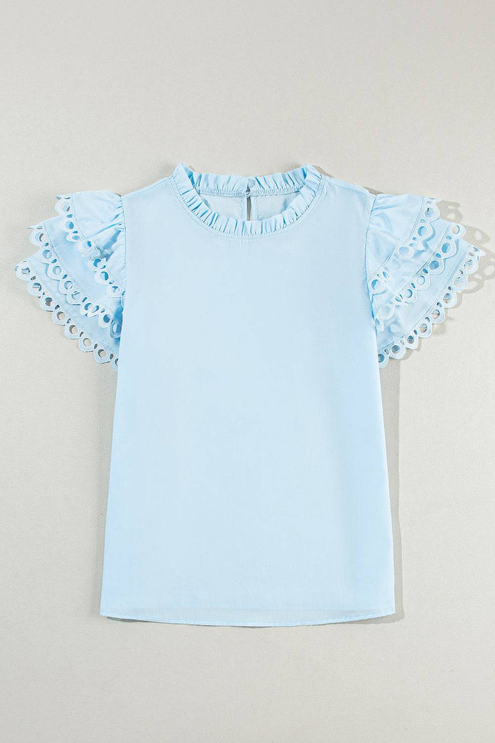 a baby blue shirt with ruffles on the sleeves