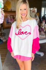 a woman wearing a white shirt with a pink heart on it