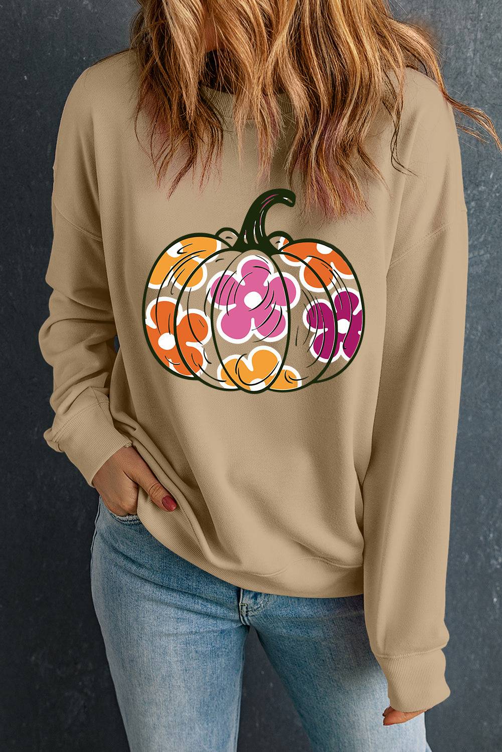 a woman wearing a sweatshirt with a pumpkin on it