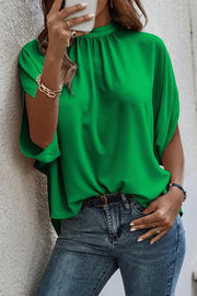 a woman in a green top is holding a cell phone