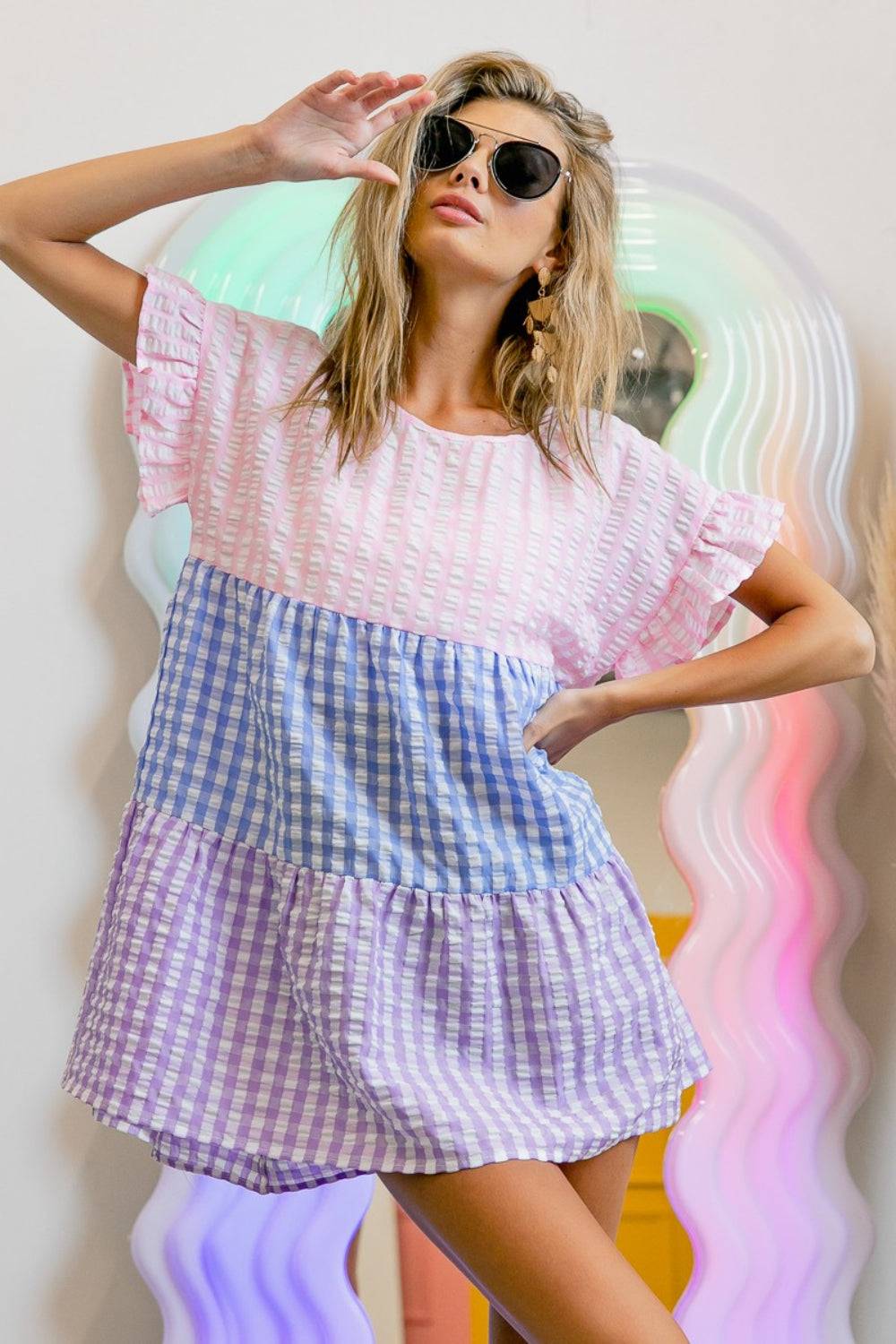 a woman in a dress and sunglasses posing for a picture