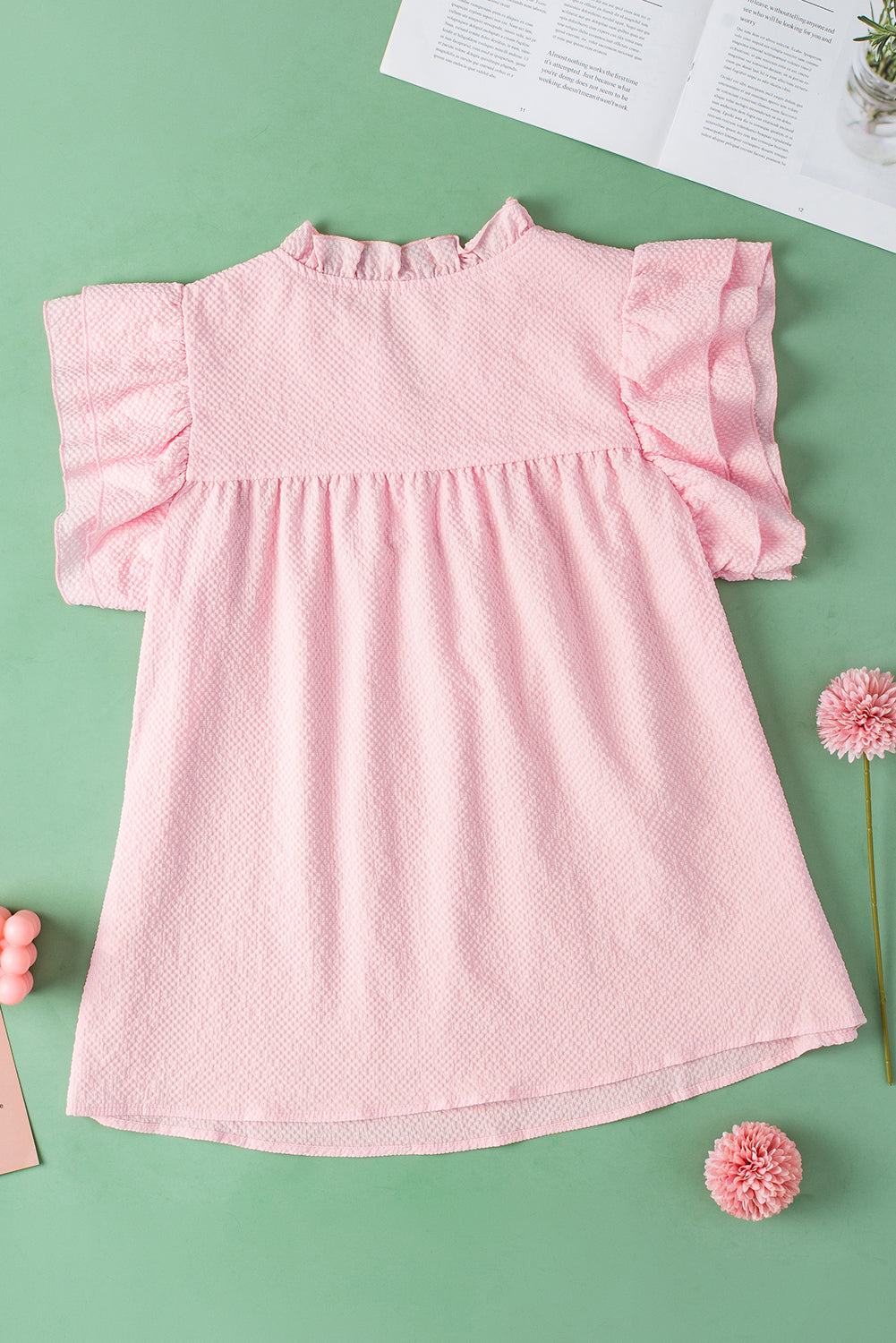 a baby girl's pink dress sitting on top of a table