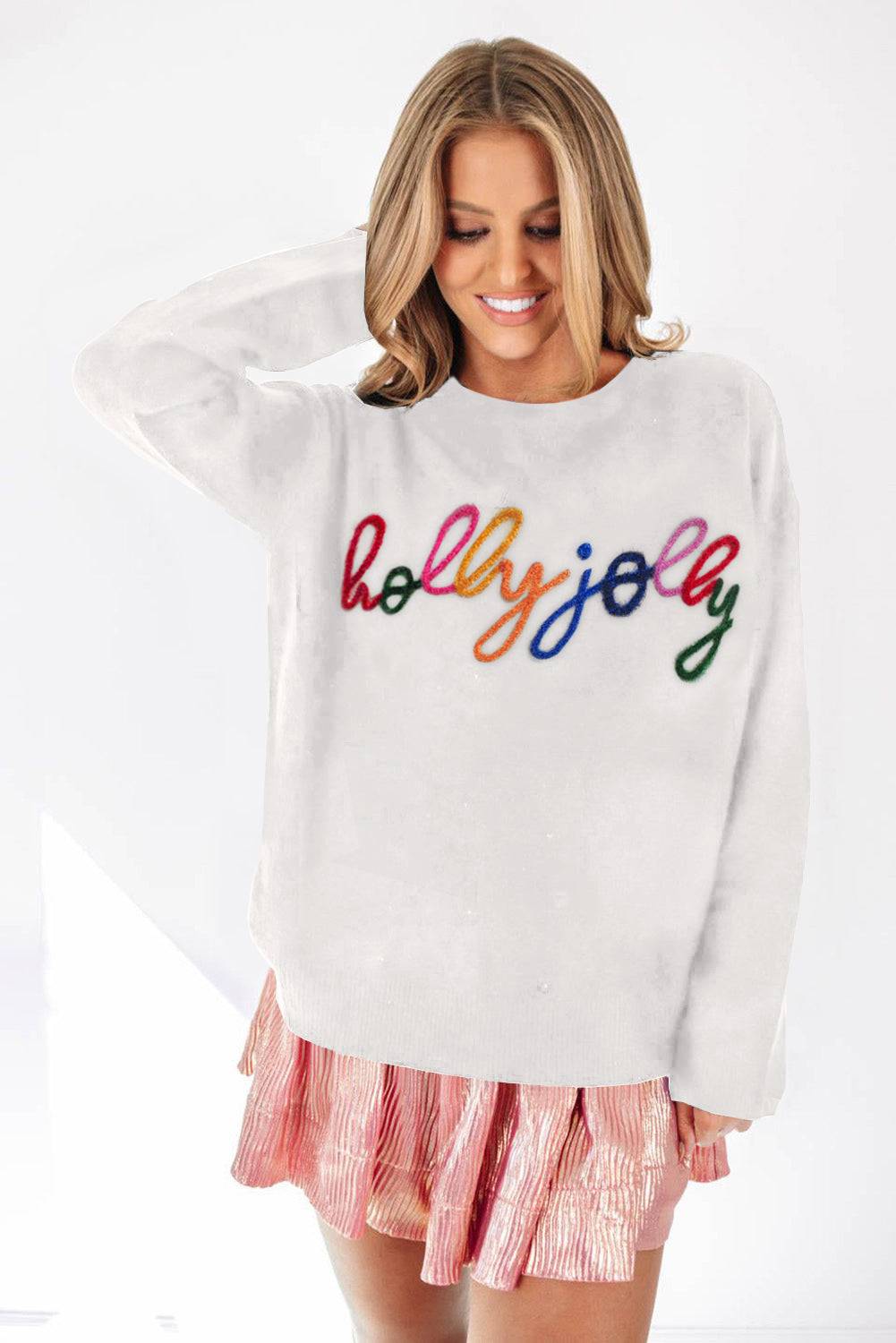 a woman wearing a white sweater with colorful lettering on it