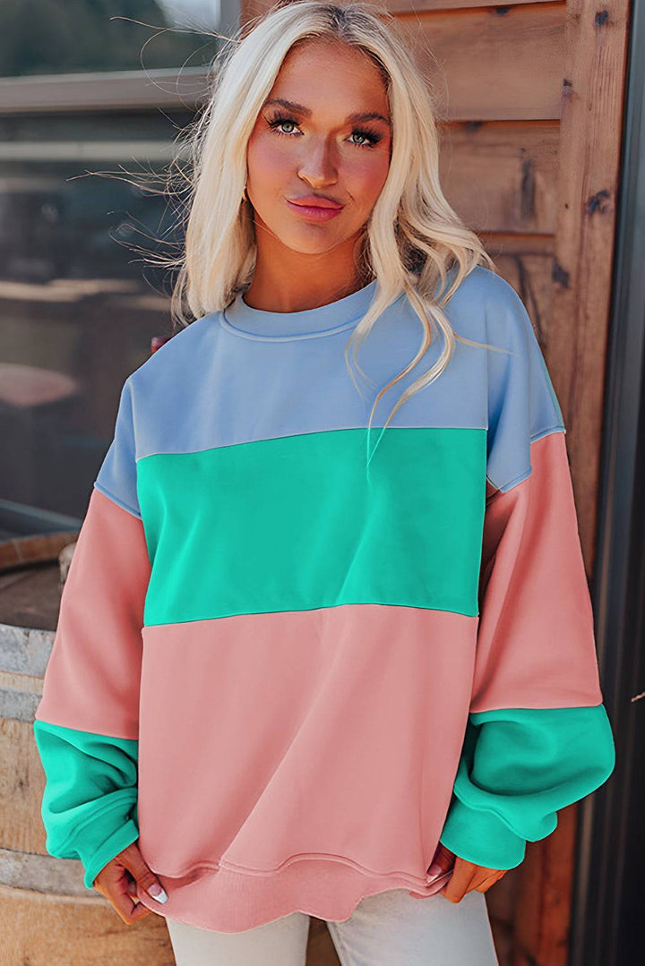 a woman standing in front of a door wearing a colorful sweater