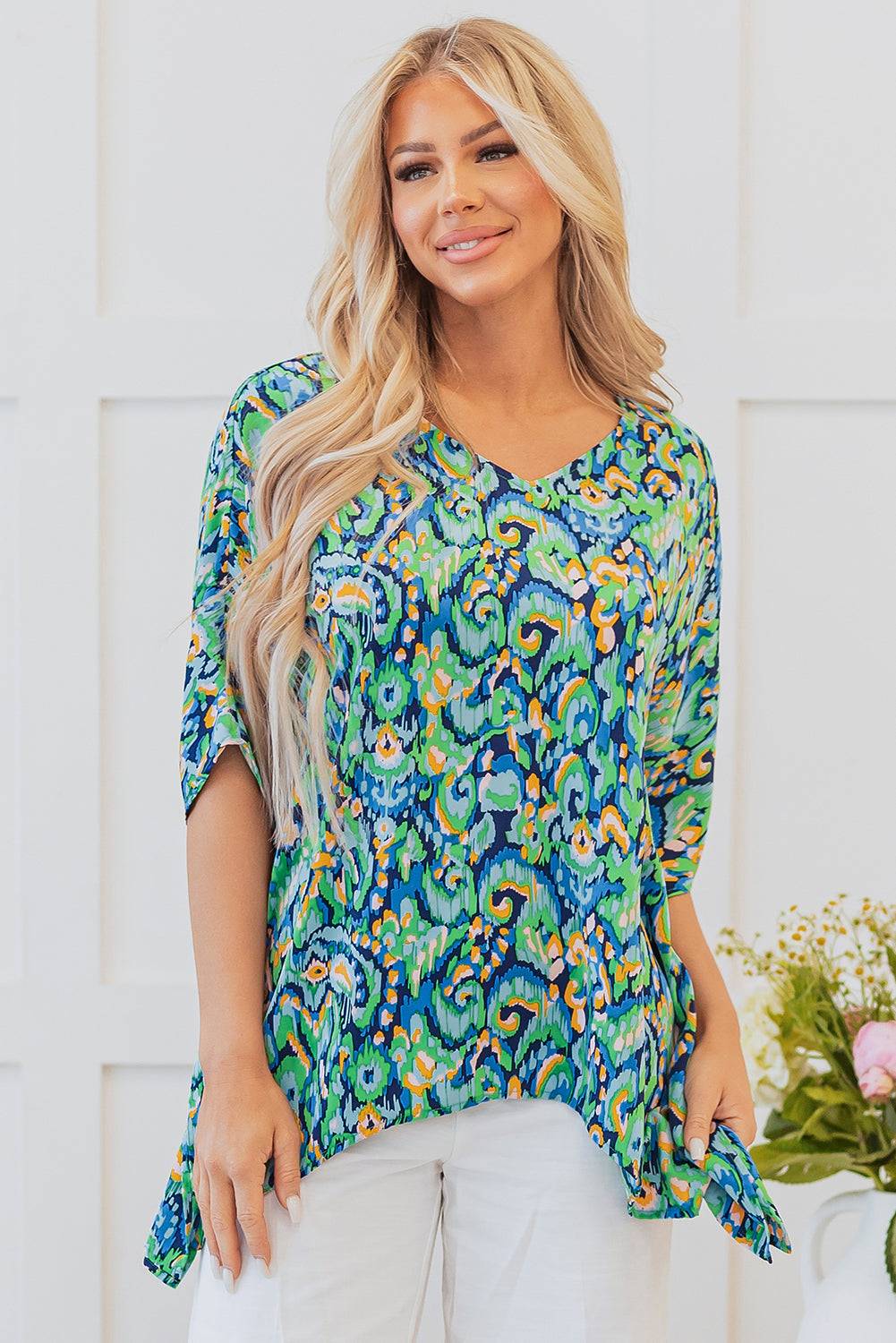 Green and blue Abstract Print V Neck Half Sleeve Loose Fit Tunic Blouse styled with white pants, great for summer outings from Faith & Co. Boutique.