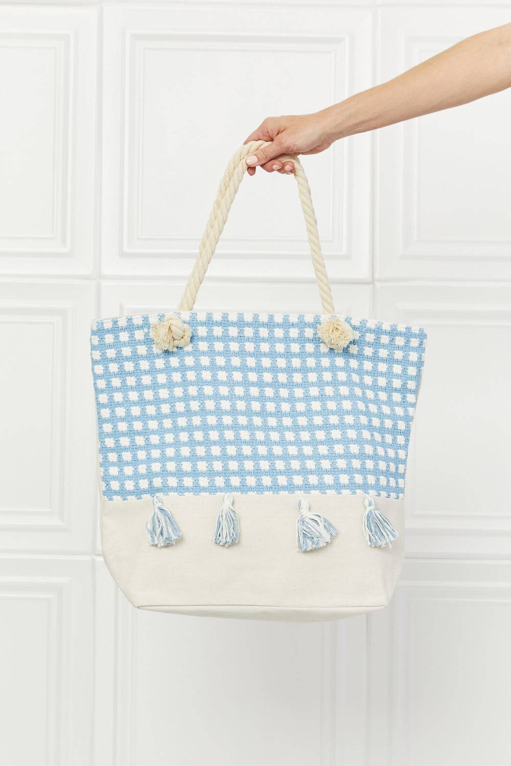 a hand holding a blue and white bag