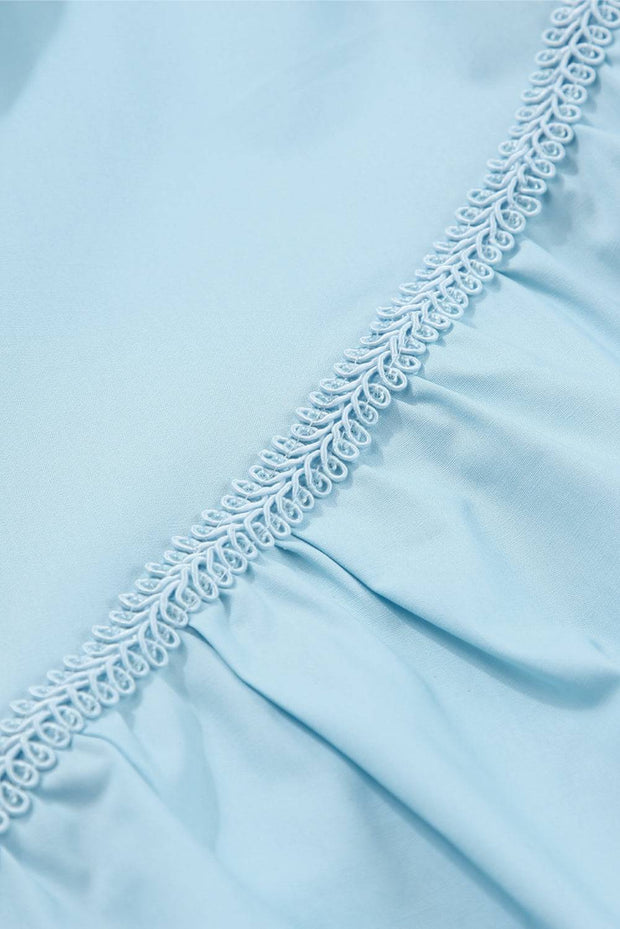 a close up of a light blue dress with white lace