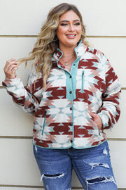 a woman standing against a wall wearing a colorful jacket