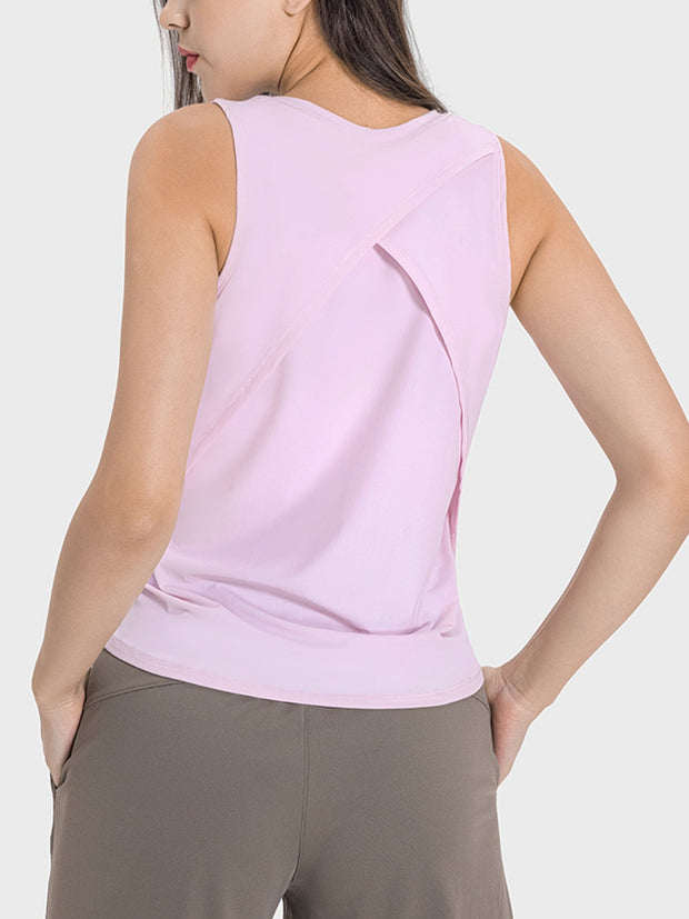 a woman wearing a pink top with a cross back