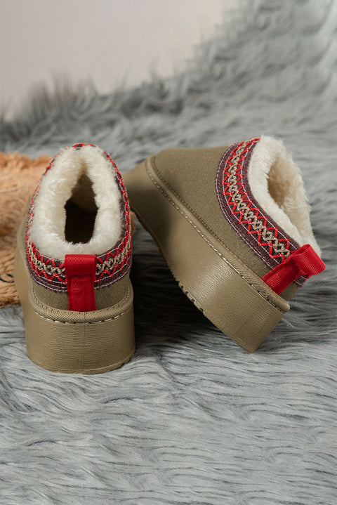 a pair of baby shoes sitting on top of a fur covered floor