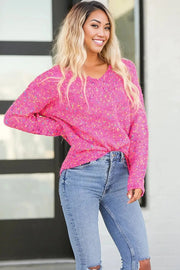 a woman wearing a pink sweater and ripped jeans
